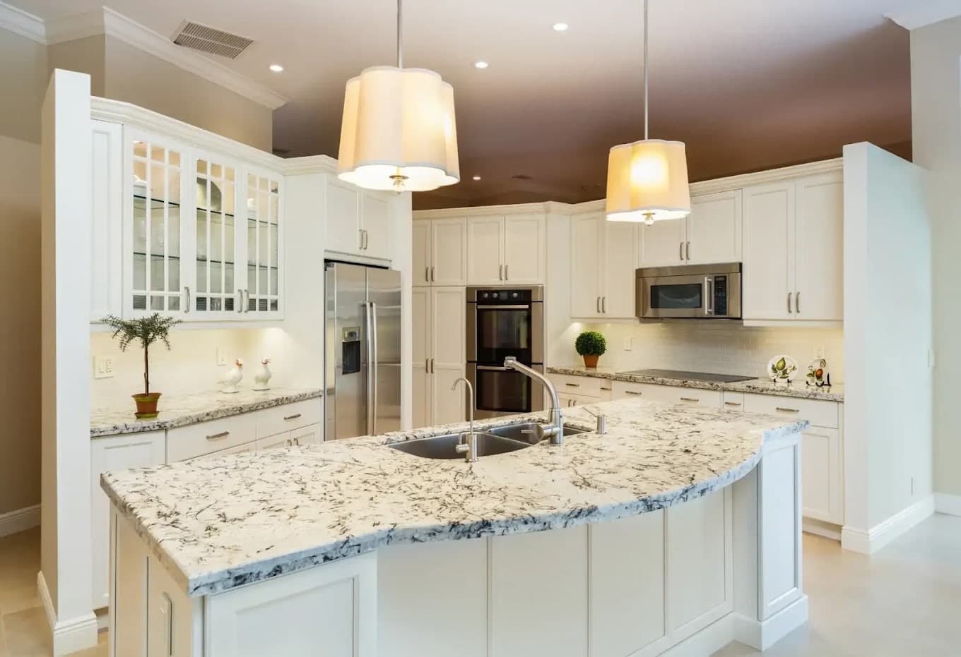 A bright kitchen with cabinets and island painted white by Revive Painting